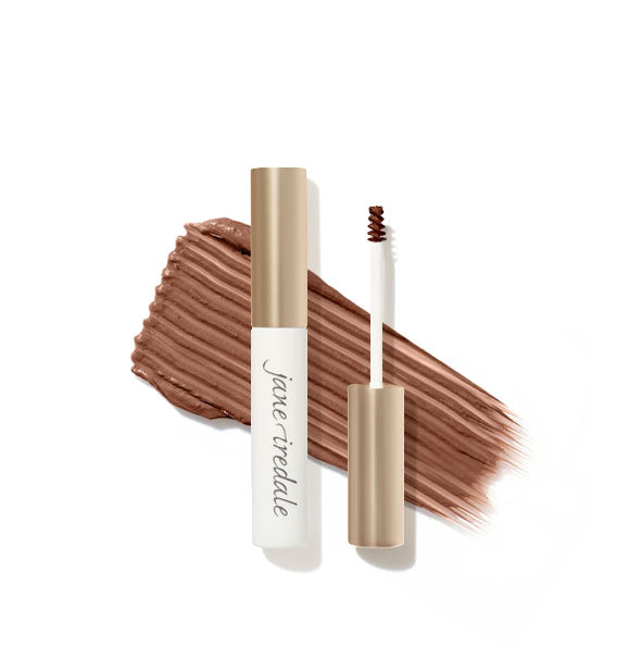 White and gold Jane Iredale brow gel tube with spoolie applicator shown features a product sample application behind in Auburn