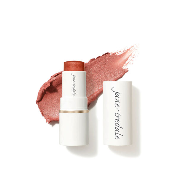 White tube of Jane Iredale Glow Time Blush Stick with cap removed and sample product application behind in shimmery shade Aura