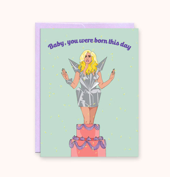 Mint green greeting card with purple envelope underneath features an illustration of Lady Gaga emerging from a cake under the words, "Baby, you were born this day" in purple lettering
