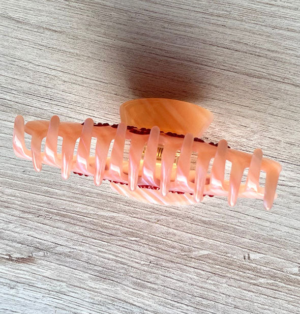 The teeth of a pink quartz-effect claw clip