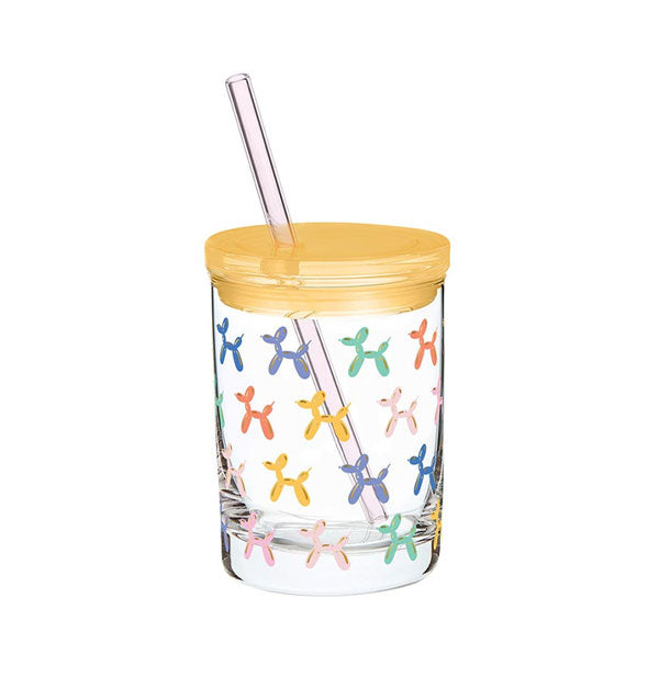 Clear glass old fashioned tumbler with yellow lid and clear straw features all-over design of colorful balloon dogs