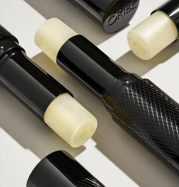 Black tubes of Oribe lip balm with diamond-shaped patterning