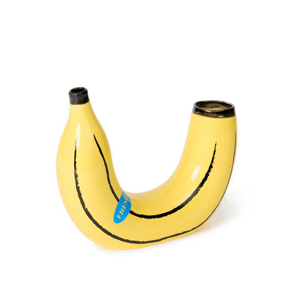 Yellow ceramic banana vase with painted black accents and a "sticker" feature has two openings, one narrower for a single stem or stalk