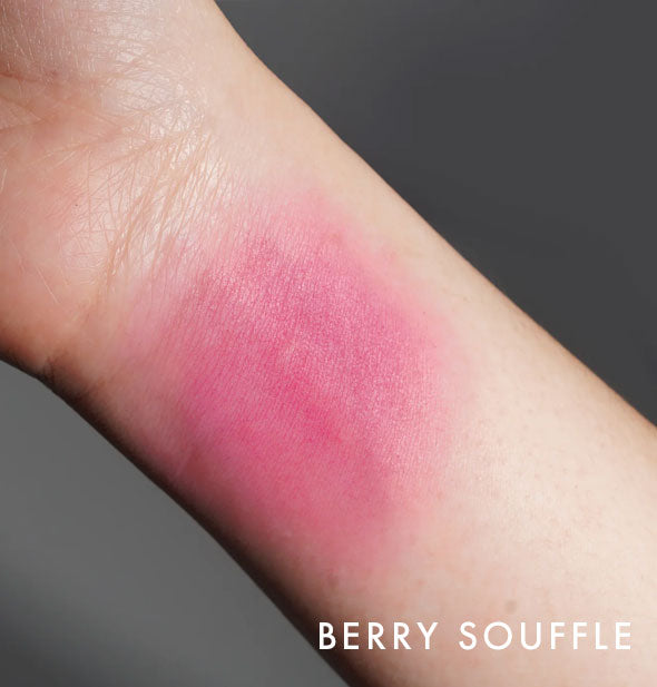 Kara Beauty Soft Serve Lip & Cheek Whip shade Berry Souffle is applied to the inside of a model's wrist