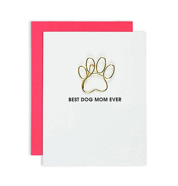 White greeting card imprinted "Best Dog Mom Ever" with gold paw-shaped paper clip attached and bright pink envelope behind.