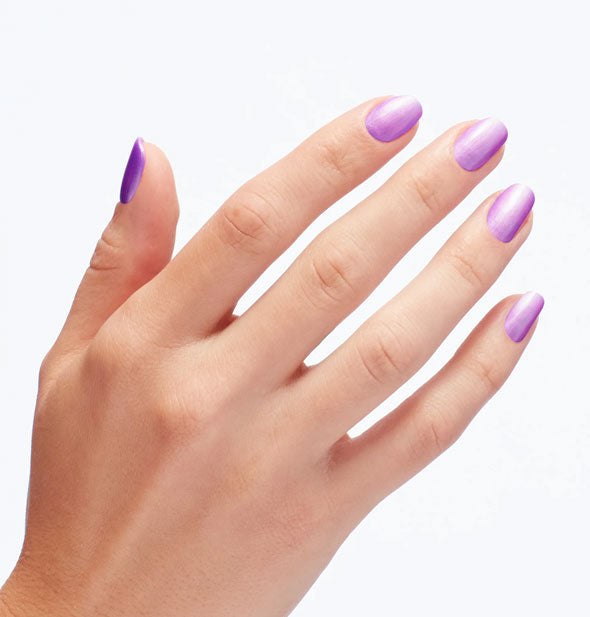 Model's fingernails are painted with shimmery purple polish