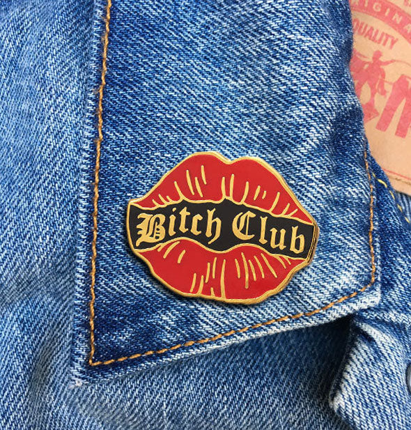 Bitch Club red lips enamel pin on a jean jacket lapel