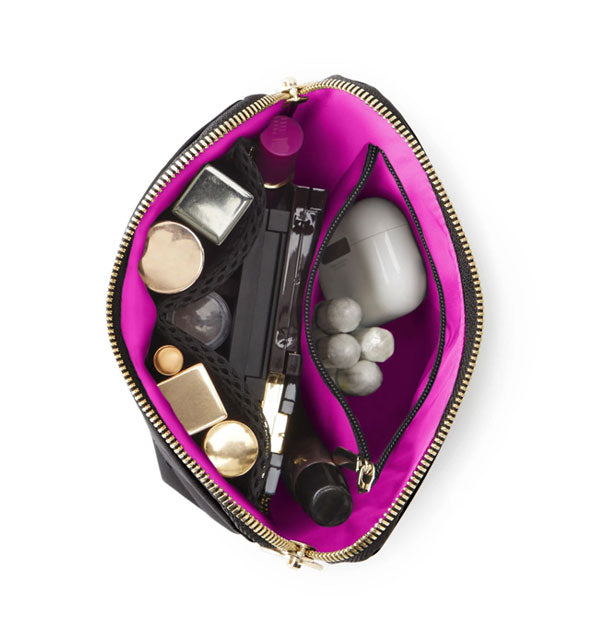 Top view of opened Everyday Makeup Bag reveals pink lining and cosmetic and toiletry items organized inside