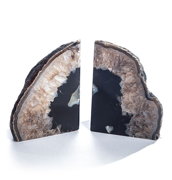 Two black agate slices with rough exteriors and polished interiors intended for use as bookends