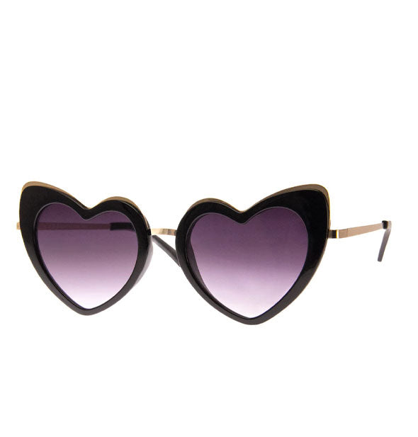 Pair of black heart-shaped sunglasses with gold details and black temple tips