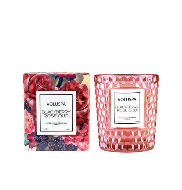 Pink embossed glass jar Voluspa Blackberry Rose Oud candle next to gift box with fruit and floral design