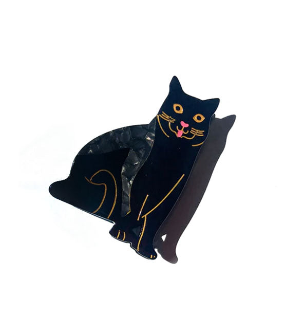 Hair clip designed and painted to resemble a black cat with pink tongue sticking out and featuring gold accent lines