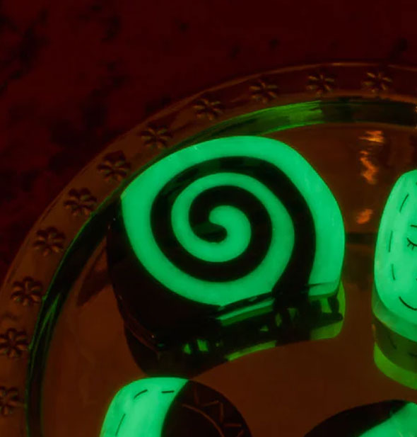 Black and green glow-in-the-dark claw clip on a gold tray with other glow-in-the-dark accessories