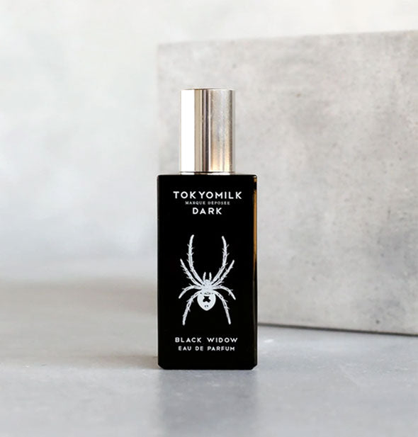 Dark bottle of TokyoMilk Black Widow Eau de Parfum with white spider graphic and silver cap