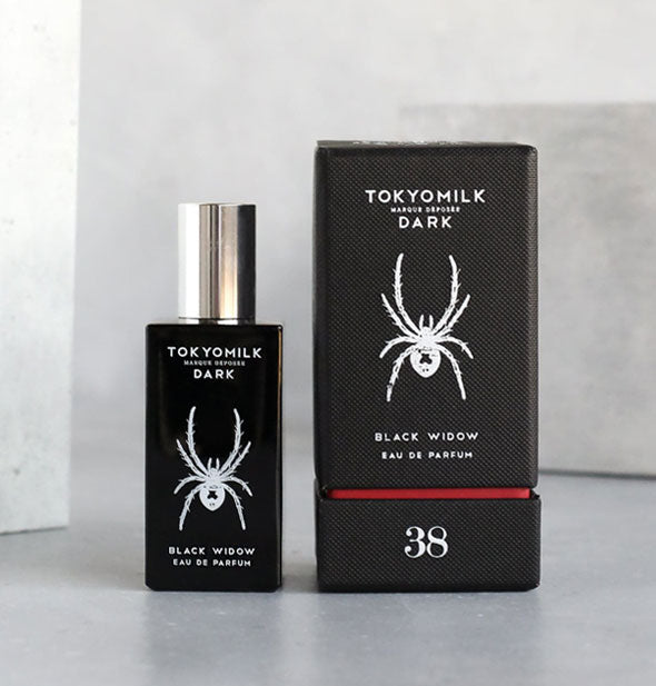 Bottle and box of TokyoMilk Black Widow Eau de Parfum with spider graphic in white