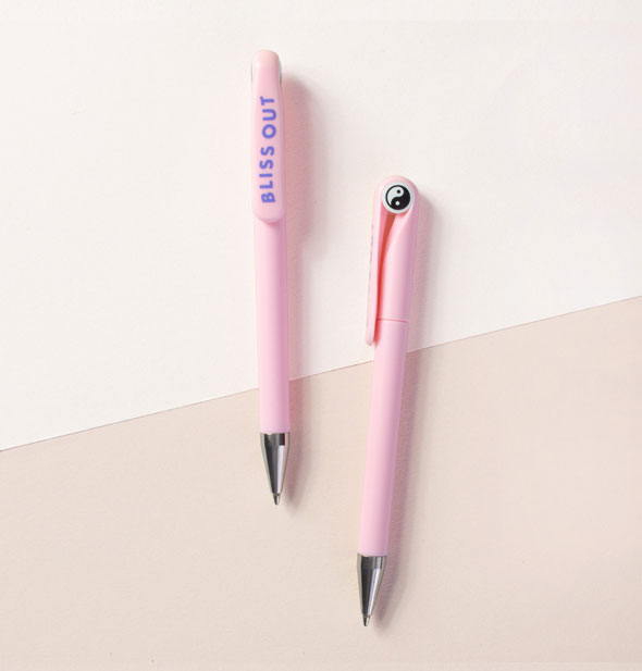 Two pink pens feature a black and white yin yang symbol on the top and the words, "Bliss Out" in purple on the clip