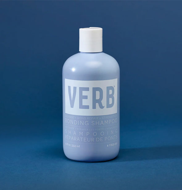 Blue and white 12 ounce bottle of Verb Bonding Shampoo on a dark blue backdrop