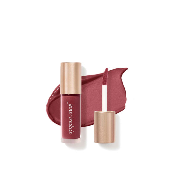 Tube of Jane Iredale Beyond Matte Lip Stain with separate gold doe foot applicator cap rest atop an enlarged sample application of product in shade Brazen