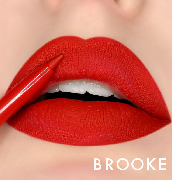 Model's lips wear shade Brooke of Kara Beauty Line Up Lip Liner; pencil tip is held up to upper lip
