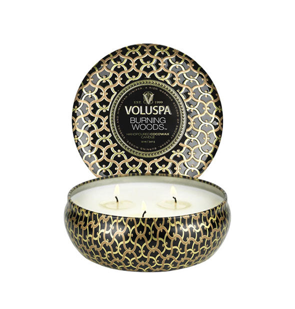 Decorative Voluspa Burning Woods candle tin with intricate pattern and three burning wicks