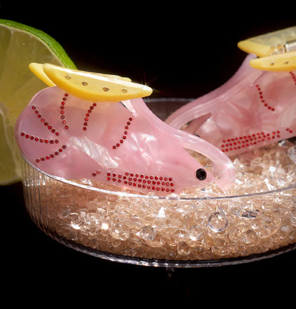 Shrimp hair clips in a cocktail glass filled with glass beads and garnished with a lime slice