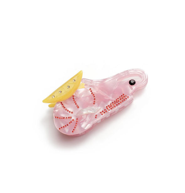 Pink quartz-effect hair clip with yellow jewel-accented top, black eye, and red dot details resembles a cocktail shrimp