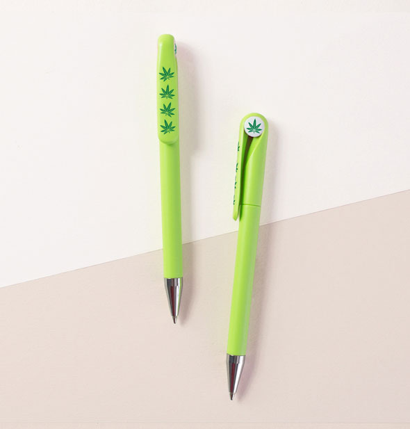 Green pens with dark green cannabis leaves printed on the top and along the clip