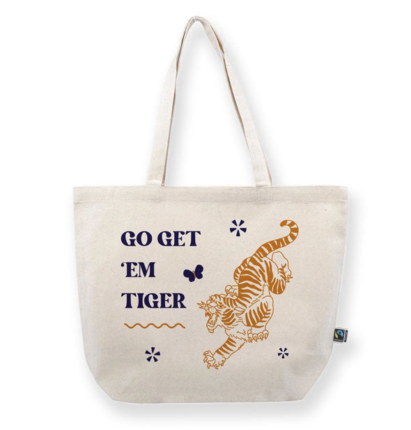 White canvas tote bag says, "Go get 'em tiger" alongside a golden roaring tiger illustration and several design accents