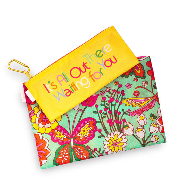 Two rectangular pouches joined by a gold carabiner: top pouch is yellow with, "It's All Out There Waiting for You" printed in multicolored lettering, and the bottom pouch is green with a colorful floral and butterfly pattern