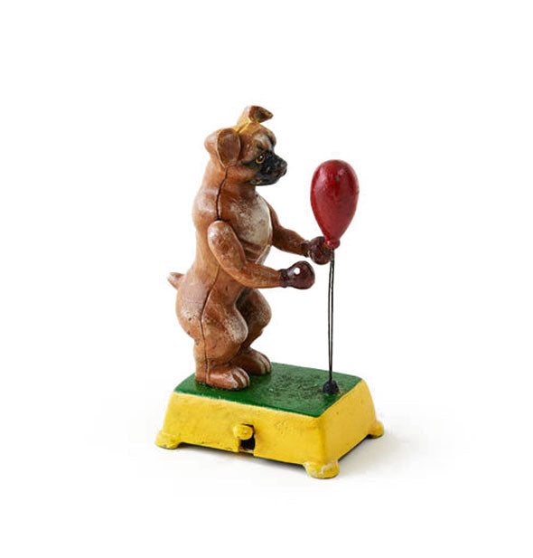 Cast iron boxer dog figurine with red punching bag on a green and yellow base with lever