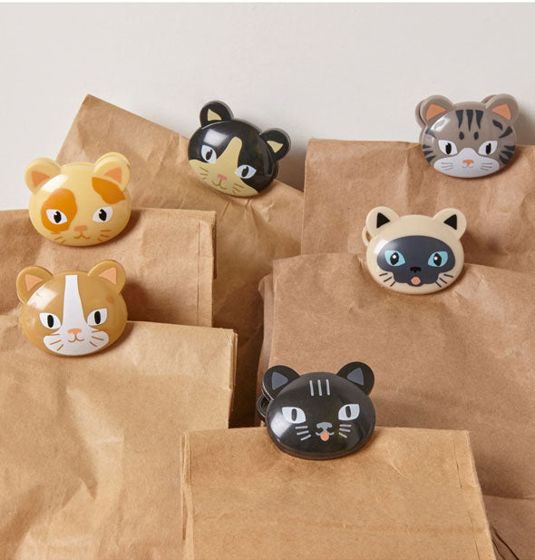 Six cat face bag clips hold brown paper bags closed