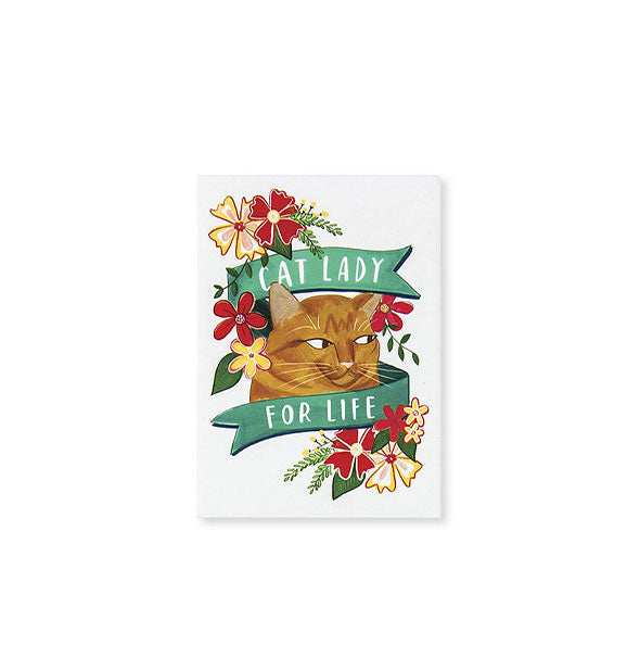 White rectangular magnet features illustration of an orange cat looking sideways surrounded by yellow and red flowers and wrapped in a green banner than says, "Cat lady for life" in white lettering