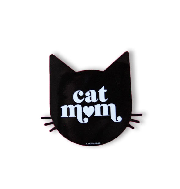 Black sticker in the shape of a cat's head with whiskers says, "Cat Mom" in white lettering with a heart in place of the "O" in "mom"