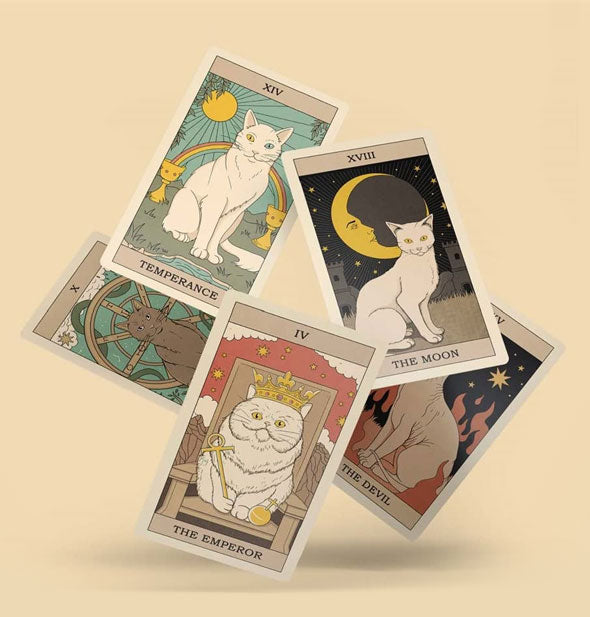 Levitating sample cards from the Cats Rule the Earth Tarot deck: Temperance, The Moon, The Emperor, and The Devil included