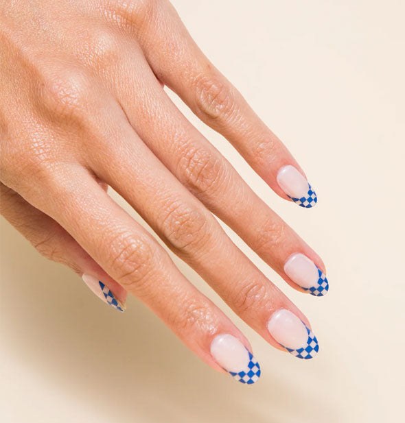 Model's hand wears a blue checker print French tip style nail