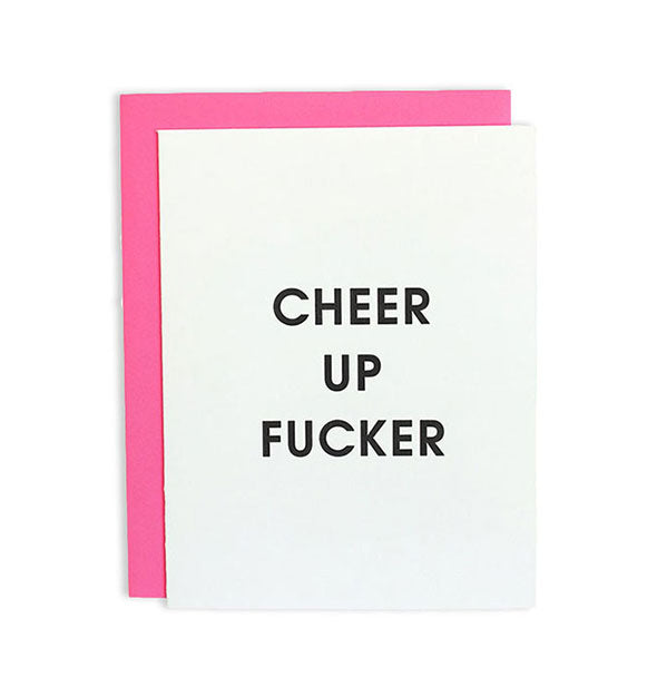 White greeting card with hot pink envelope behind says, "Cheer up fucker" in black lettering