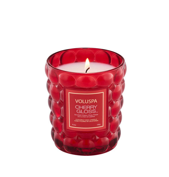 Lit Cherry Gloss Voluspa candle in textured red glass vessel