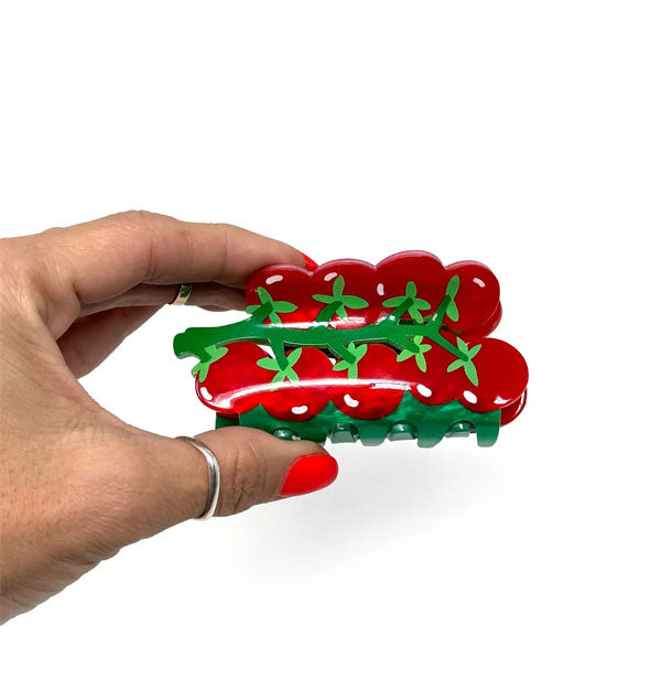 Model's hand holds the cherry tomato vine claw clip for size reference