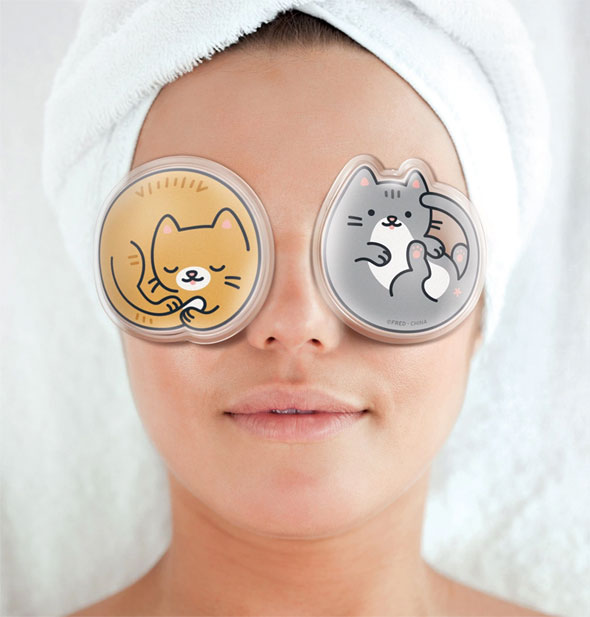 Model with hair wrapped up in a white towel wears a pair of curled-up cartoon kitten gel pads over eyes