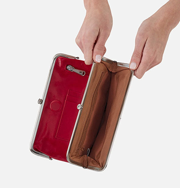 Model's hold open a red leather wallet compartment with brown lining and silver frame hardware