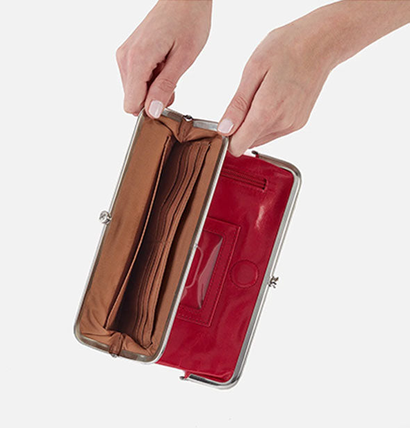 Model's hold open a red leather wallet compartment with brown lining and silver frame hardware