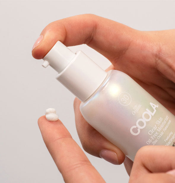Model applies a small dollop of Coola Clear Skin Oil-Free Moisturizer to fingertip