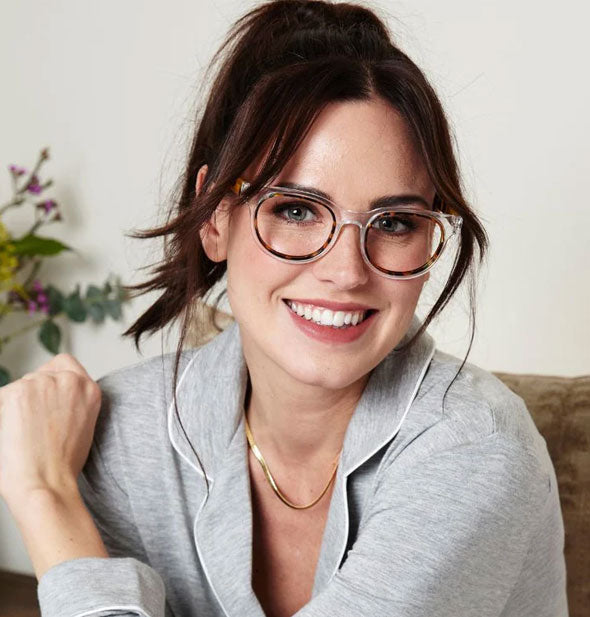 Smiling model wears a pair of clear and tortoise Olympia reading glasses