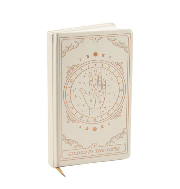 Cream-colored journal with gold ribbon bookmark and celestial/zodiac/palmistry design says, "Guided by the Stars" at the bottom