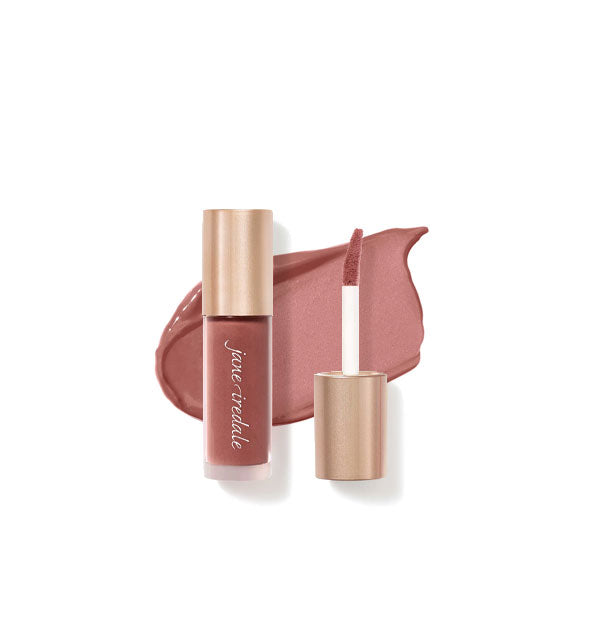 Tube of Jane Iredale Beyond Matte Lip Stain with separate gold doe foot applicator cap rest atop an enlarged sample application of product in shade Compulsion