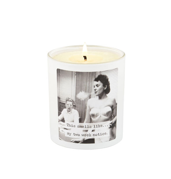 Lit jar candle features black and white photograph of a woman in a bra blowing out a puff of smoke while another woman seated at a desk looks on in the background and the caption, "This smells like...my two week notice."