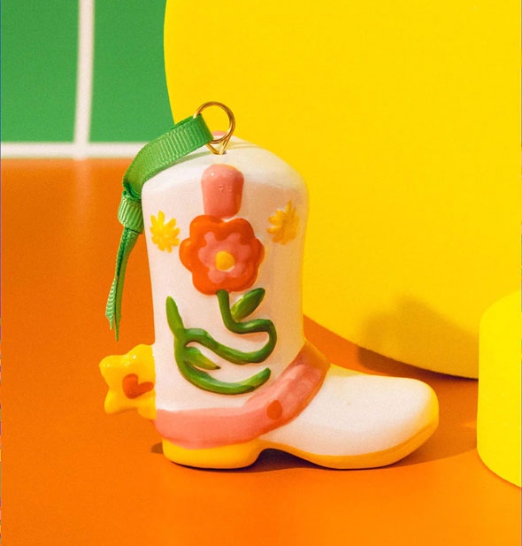 Colorful Cowboy Boot Ornament against an orange, yellow, and green backdrop
