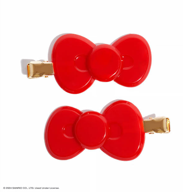 Two bright red bow-shaped clips with gold hardware