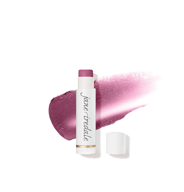 White tube of Jane Iredale lip balm with cap removed overtop a sample application of product in a dark purple shade