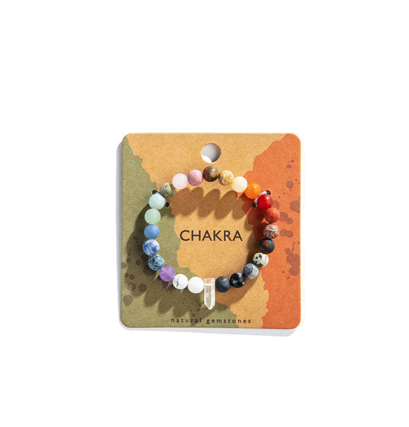 Colorful chakra stone bead bracelet with central clear crystal point on blister card